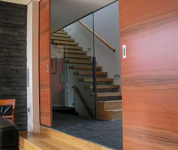 Eine große Schiebetür teilt einen Raum. Im Hintergrund eine Treppe nach oben