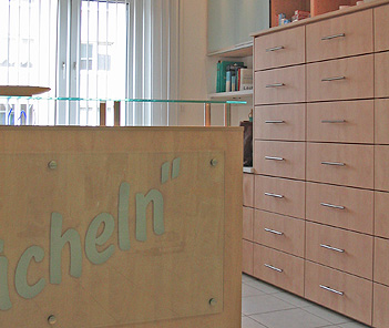 Tresen und Schränke aus hellem Holz in einer Arztpraxis